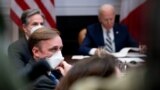 White House national security adviser Jake Sullivan, front, Secretary of State Antony Blinken, background-left, attend a meeting with President Joe Biden, right, in the Roosevelt Room of the White House, in Washington, March 1, 2021. 