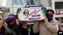 Women activists carry a mock coffin of Ayse Pasali, who was shot to death by her ex-husband, during a demonstration, planned as an alternative to Valentine's Day, in central Istanbul, February 14, 2011