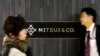 Orang-orang berjalan melewati logo perusahaan perdagangan Jepang Mitsui & Co di Tokyo, Jepang, 10 Januari 2018. (Foto: REUTERS/Toru Hana)