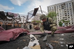 FILE - A sapper inspects fragments of a Russian air bomb that hit a living area, injuring 10, in Kharkiv, Ukraine, May 22, 2024.