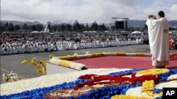 Un sacerdote toma fotografías de la multitud antes de una misa celebrada por el papa Francisco en el Parque Bicentenario en Quito, Ecuador, el martes 7 de julio de 2015. 