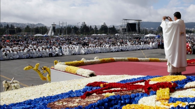 Un sacerdote toma fotografías de la multitud antes de una misa celebrada por el papa Francisco en el Parque Bicentenario en Quito, Ecuador, el martes 7 de julio de 2015. 