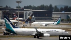 Pesawat Boeing 737 Max 8 milik maskapai penerbangan A SilkAir di tarmac dekat hangar di Bandara Changi, Singapore, 12 Maret 2018. (Foto: dok).