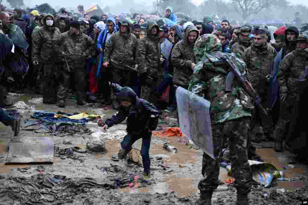 A boy passes from the northern Greek village of Idomeni to southern Macedonia as other refugees and migrants wait, Sept. 10, 2015. Thousands of people, including many families with young children, braved torrential downpours to cross Greece&rsquo;s northern border with Macedonia, after Greek authorities managed to register about 17,000 people on the island of Lesbos, allowing them to continue their journey north into Europe.