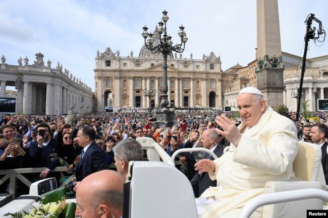 El papa Francisco saluda a la multitud reunida en la Plaza de San Pedro del Vaticano para la misa del Domingo de Ramos el 2 de abril de 2023.