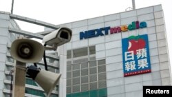 FILE - A security camera is seen in front of the headquarters of Apple Daily and Next Media in Hong Kong.