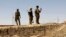 FILE - Iraqi soldiers patrol along the border between Syria and Iraq in Anbar province, Iraq. 