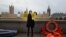 An activist from Amnesty International wearing a mask depicting Britain's Home Secretary Priti Patel, demonstrates ahead of the Government's Nationality and Borders Bill, opposite the Houses of Parliament, on the banks of the River Thames in London on Dec. 7, 2021.
