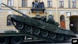 Sebuah tank T-72 Rusia diturunkan dari kendaraan pengangkut hari Kamis tanggal 28 April 2016 untuk latihan parade militer Hari Kemenangan di Lapangan (Istana) Dvortsovaya, St. Petersburg, Rusia, tanggal 9 Mei nanti (foto: AP Photo/Dmitri Lovetsky)