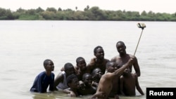 Un groupe de jeunes prennent un selfie avec une perche à selfie près de Khartoum au Soudan, le 22 mai 2015.