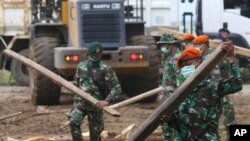 Soldiers remove debris from a damaged house in the tsunami-hit village of Carita, Indonesia, Dec. 28, 2018.