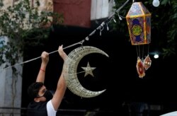 Seorang pria meletakkan dekorasi Ramadhan di jalan menjelang bulan suci Muslim, selama lockdown akibat COVID-19 di Beirut, Lebanon, 19 April 2020. (Foto: Reuters)