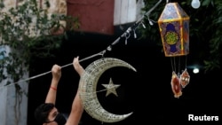 A man puts Ramadan decorations on a street ahead of the Muslim holy month, during a countrywide lockdown over the coronavirus disease (COVID-19) in Beirut, Lebanon, April 19, 2020.