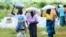 FILE: Women carry bags of maize during a food aid distribution excercise in Mudzi about 230 kilometres northeast of the capital Harare, Zimbabwe, Feb, 20, 2020.