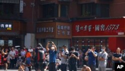 FILE - Residents and journalists gather as the Chinese authorities secure the United States Consulate in Chengdu in southwest China's Sichuan province, July 27, 2020.