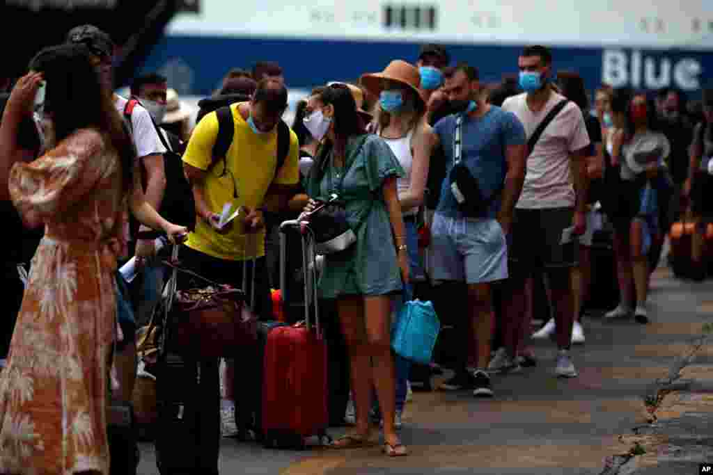 مسافران در فرودگاه آتن. بعد از مدتها پرواز‌ها از سر گرفته شده اما احتیاط و ایمنی موجب کندی خدمات فرودگاهی شده است. 