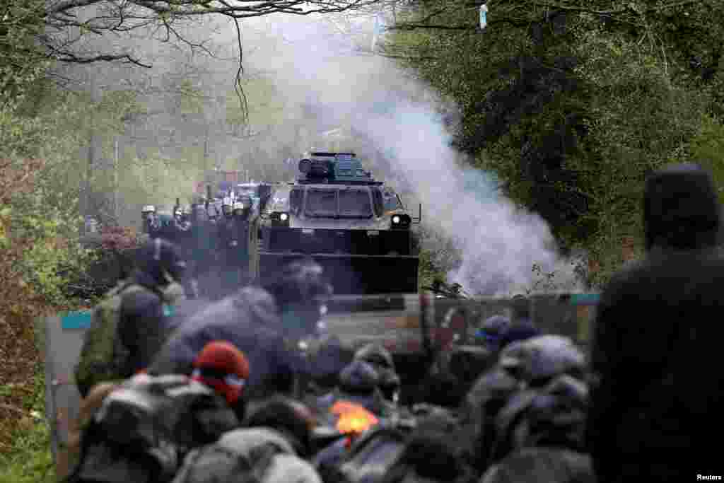 Protesters gather on a road as French gendarmes advance with an armored vehicle during clashes during an evacuation operation in the zoned ZAD (Deferred Development Zone) in Notre-Dame-des-Landes, near Nantes, France.