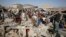 FILE - People gather on the rubble of shops destroyed by a Saudi-led airstrike at a market in Sana'a, Yemen, July 20, 2015. 