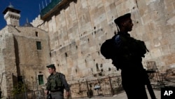 FILE - Israeli border police stand guard on the site known to Jews as the Tomb of the Patriarchs, and to Muslims as the Ibrahimi Mosque, in the West Bank city of Hebron, Jan. 14, 2013.