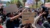 Un manifestant tient une pancarte au cours de la deuxième journée des manifestations, où des centaines de jeunes Namibiens ont protesté contre la violence sexiste en fermant le quartier central des affaires de Windhoek, en Namibie, le 9 octobre 2020. (Photo by HILDEGARD TITUS / A