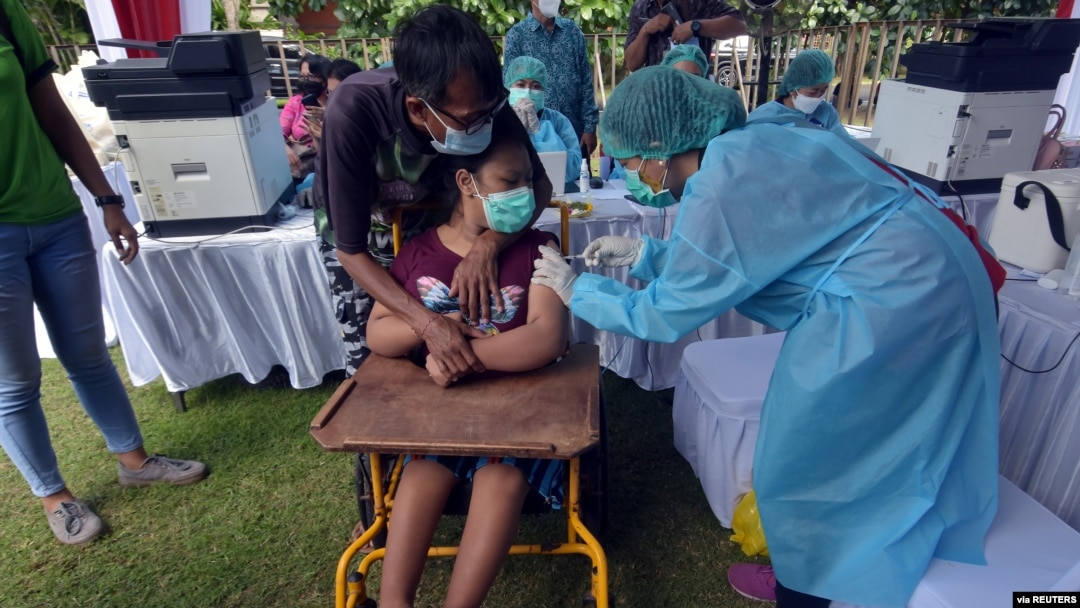A woman with disabilities receives a dose of the vaccine against the coronavirus disease (COVID-19) during a mass vaccination program in Denpasar, Bali, Indonesia, Sept. 7, 2021, in this photo taken by Antara Foto/Nyoman Hendra Wibowo/via REUTERS.