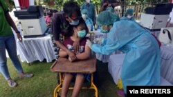 A woman with disabilities receives a dose of the vaccine against the coronavirus disease (COVID-19) during a mass vaccination program in Denpasar, Bali, Indonesia, Sept. 7, 2021, in this photo taken by Antara Foto/Nyoman Hendra Wibowo/via REUTERS.