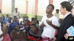 The United Nations Secretary General's special advisor on piracy legal issues Jack Lang, from France, right, listens to an unidentified suspected Somali pirate, on remand, at the Shimo la Tewa GK Prison in Mombasa, Kenya, 11 Oct 2010