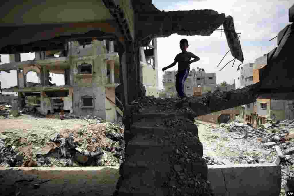 A Palestinian boy plays amid the rubble of his familiy&#39;s former house which was destroyed during the 50-day war between Israel and Hamas militants in the summer of 2014, in the Eastern Gaza City Shujaiya neighborhood.