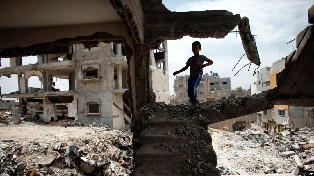 FILE - A Palestinian boy plays amid the rubble of his family's former house which was destroyed during the 50-day war between Israel and Hamas militants in the summer of 2014, in the Eastern Gaza City Shujaiya neighborhood, May 11, 2015.