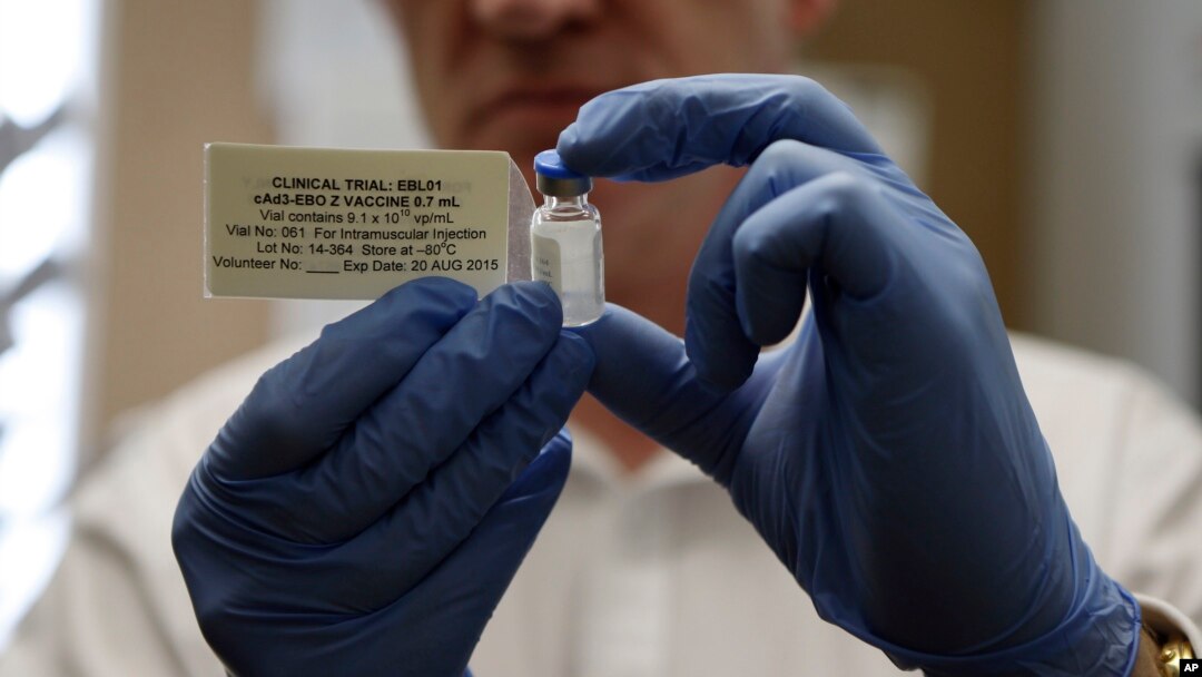 FILE - A researcher holds a vial of an experimental Ebola vaccine in Oxford, England, Sept. 17, 2014.
