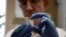 FILE - A researcher holds a vial of an experimental Ebola vaccine in Oxford, England Wednesday Sept. 17, 2014.