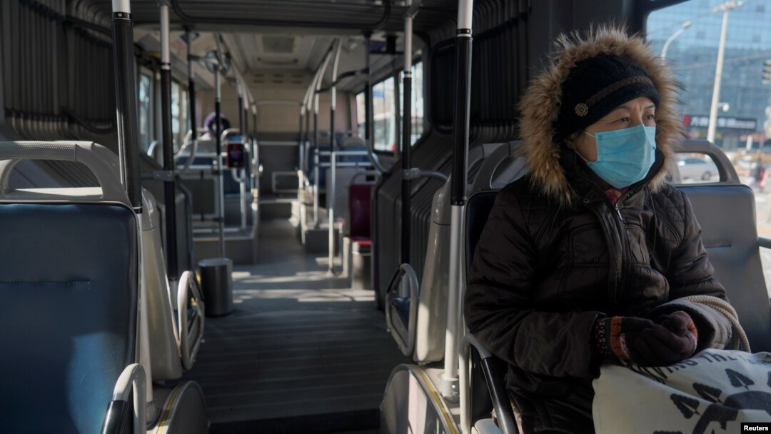 Seorang perempuan mengenakan masker di sebuah bus di tengah wabah virus korona yang melanda negara itu, di Beijing, China, 15 Februari 2020. 