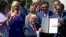 President Donald Trump holds up an executive order that he signed during a National Day of Prayer event in the Rose Garden of the White House in Washington, May 3, 2018.