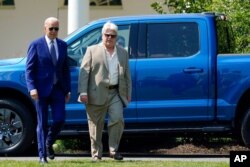 President Joe Biden walks with United Auto Workers Local 600 president Bernie Ricky before he speaks on the South Lawn of the White House in Washington, Aug. 5, 2021.