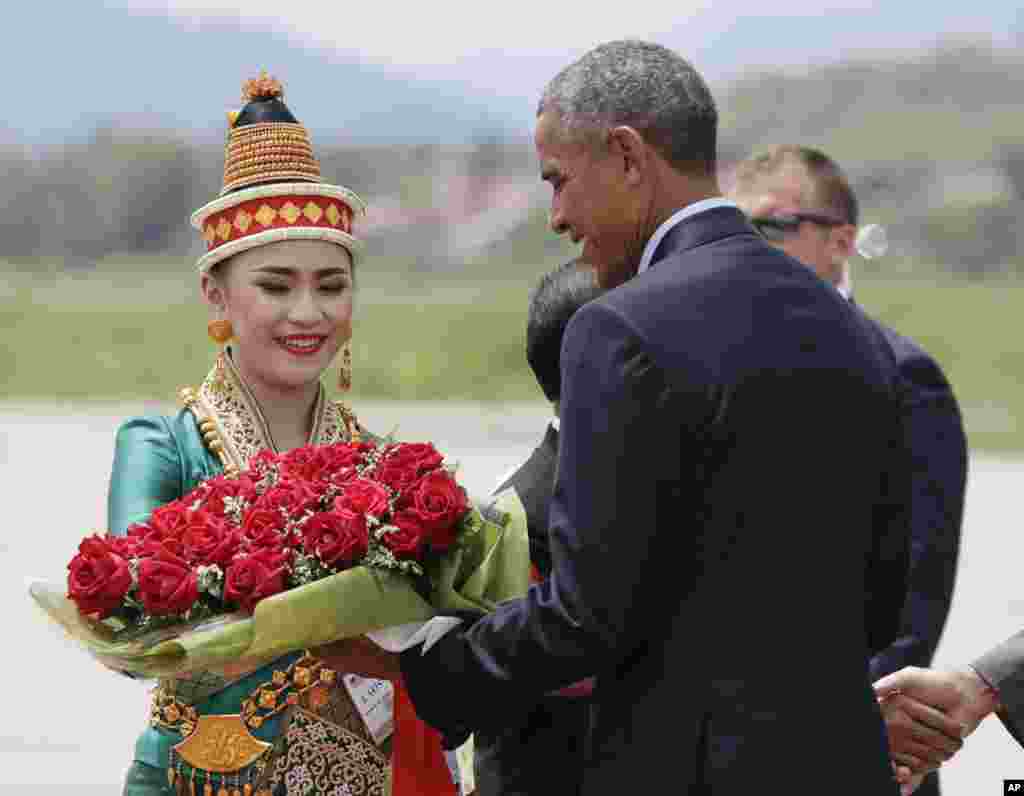 U.S. President Barack Obama receives flowers as he arrives at the Luang Prabang International Airport in Laos, Sept. 7, 2016.