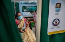 An elderly woman receives the COVID-19 vaccine at a private hospital in Gauhati, India, March 4, 2021.