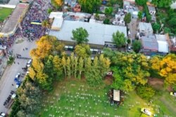 Relatives and friends bury the remains of Diego Maradona while police keep fans outside the Jardin de Bellavista cemetery in Buenos Aires, Argentina, Nov. 26, 2020.