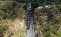 Migrants walk along a highway in hopes of reaching the United States, near Agua Caliente, Guatemala, Jan. 16, 2020, on the border with Honduras. Hundreds of Honduran migrants started walking and hitching rides the day before at San Pedro Sula.