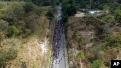 FILE - Migrants walk along a highway hoping to reach the faraway United States near Agua Caliente, Guatemala, on the border with Honduras, on January 16, 2020.