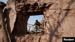 A resident collects items from the rubble of a house after it was damaged by grenades from gunmen on the outskirts of the northwestern city of Peshawar, Pakistan, Feb. 12, 2014.