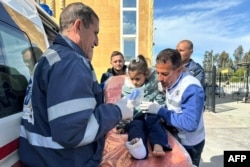 An injured Palestinian child is transported on a gurney into an Egyptian Red Crescent ambulance after evacuation from the Gaza Strip via the Rafah border crossing into Egypt on Feb. 1, 2024.