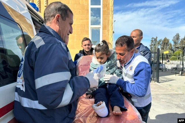 An injured Palestinian child is transported on a gurney into an Egyptian Red Crescent ambulance after evacuation from the Gaza Strip via the Rafah border crossing into Egypt on Feb. 1, 2024.