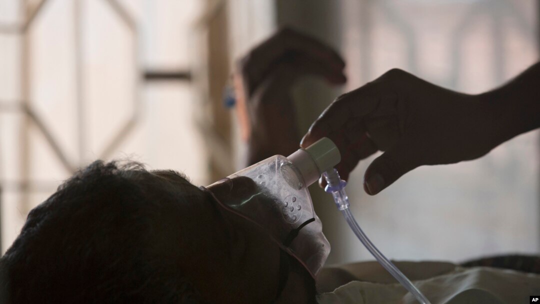 A relative adjusts the oxygen mask of a tuberculosis patient at a TB hospital on World Tuberculosis Day in Hyderabad, India, March 24, 2018. 