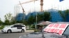 2023年8月17日，在北京郊区正在建设中的碧桂园·和世界项目附近，一辆挂着“碧桂园业主维权车”标语的汽车停在业主们露营的地方。此前，这家大型房地产开发商未能偿还数千亿人民币的债务，引发了人们对房地产行业财务状况不稳定及其对举步维艰的中国经济影响的担忧。