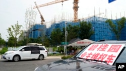 2023年8月17日，在北京郊区正在建设中的碧桂园·和世界项目附近，一辆挂着“碧桂园业主维权车”标语的汽车停在业主们露营的地方。此前，这家大型房地产开发商未能偿还数千亿人民币的债务，引发了人们对房地产行业财务状况不稳定及其对举步维艰的中国经济影响的担忧。