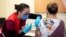 Nurse Venus Lucero administers the first Pfizer-BioNTech COVID-19 vaccine at the Civic Hospital to Jo-Anne Miner at a vaccination clinic in Ottawa, Ontario, Canada, Dec. 15, 2020.