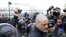 Police officers detain opposition activist Sergei Udaltsov outside the NTV television station in Moscow, Sunday, March, 18, 2012.