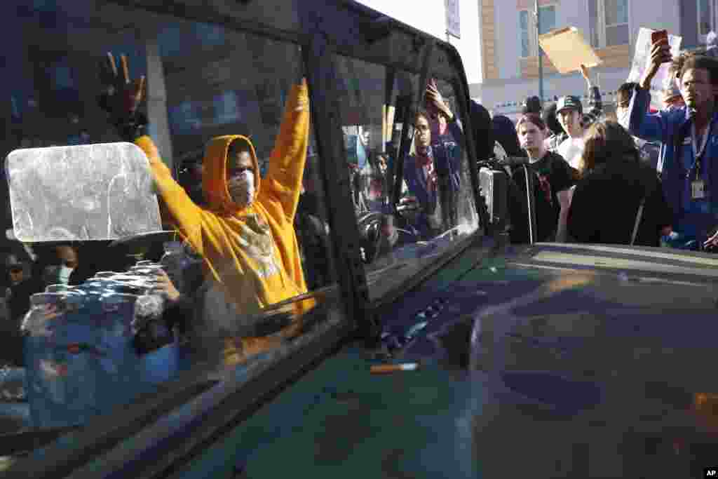 Protesters stand near a Minnesota National Guard vehicle Friday, May 29, 2020, in Minneapolis. Protests continued following the death of George Floyd, who died after being restrained by Minneapolis police officers on Memorial Day. (AP Photo/John…