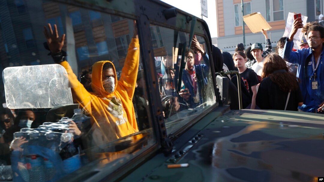 Protesters stand near a Minnesota National Guard vehicle Friday, May 29, 2020, in Minneapolis.