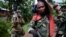 FILE - Congolese government army soldiers carry weapons and mortar equipment on the road to the border town of Bunagana, after their unit returned from the frontline of fighting against rebel forces, in Kinyamahura, Congo.
